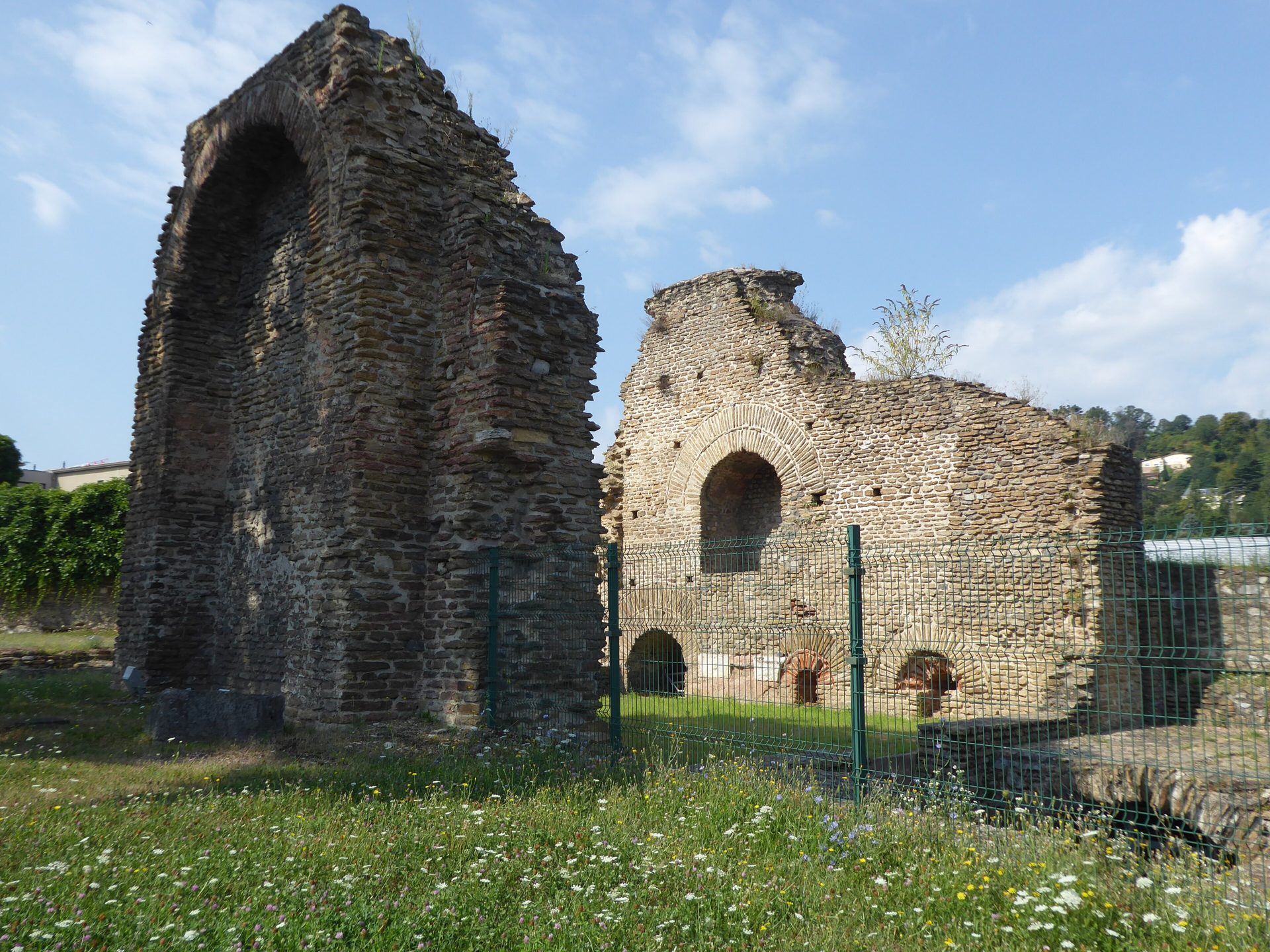Les hauts murs en ruine des thermes antiques sous un ciel bleu